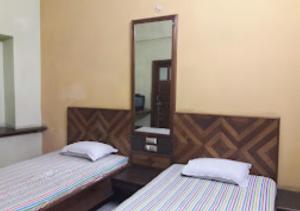 a bedroom with two beds and a mirror at Hotel Solan Rourkela in Rourkela