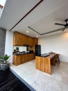 a kitchen with wooden cabinets and a black counter top at Gyanesh Villa in Ubud