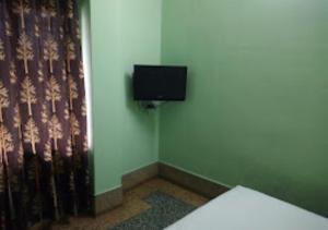 Ecke eines Zimmers mit einem TV an der Wand in der Unterkunft Hotel Solan Rourkela in Rourkela