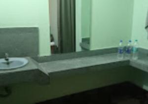 a bathroom with a sink and a mirror at Hotel Solan Rourkela in Rourkela