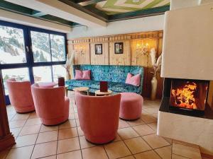 a living room with a couch and a fireplace at Andi's Skihotel in Obertauern