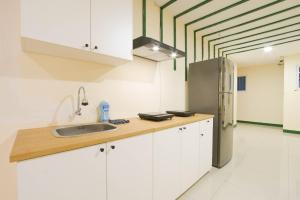 a kitchen with white cabinets and a stainless steel refrigerator at Le Paris Syariah Residence in Tangerang