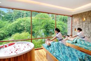 烏布的住宿－Kaamala Resort Ubud by Ini Vie Hospitality，一间带2位女性床和浴缸的spa室