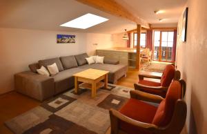 ein Wohnzimmer mit einem Sofa und einem Tisch in der Unterkunft Brunnenhof Apartments in Pettneu am Arlberg