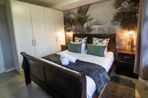 a bedroom with a large bed with green pillows at Stay at The Point - Warm Welcome Winner in Durban