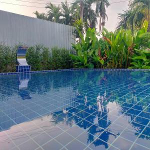 una piscina con azulejos azules en el agua en Davy Cottage Phuket en Ban Riang
