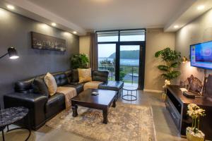 a living room with a couch and a tv at Stay at The Point - Warm Welcome Winner in Durban