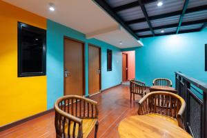 una habitación con 3 sillas de madera y un bar en Sans Hotel Suryakencana Bogor en Bogor