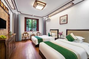 um quarto de hotel com duas camas e uma televisão em Tongli Lanshe Garden B&B em Suzhou