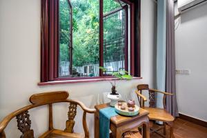 un tavolo e due sedie in una stanza con finestra di Tongli Lanshe Garden B&B a Suzhou