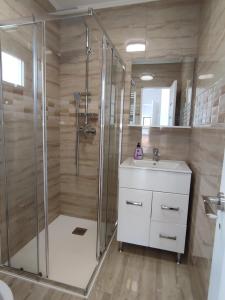 a bathroom with a shower and a sink at Agropensiunea DAVID SI MARIA in Niculiţel