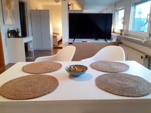 un tavolo con quattro tappetini sopra con una ciotola di noci di Chic Apartment in Obertshausen a Obertshausen