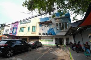 um edifício com um carro estacionado em frente em Athena Syariah Residence em Tangerang