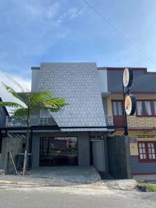 un edificio con una palma di fronte di OTOUSAN HOUSE a Bukittinggi