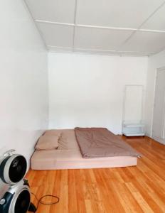 Camera bianca con letto e pavimento in legno. di OTOUSAN HOUSE a Bukittinggi