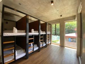 a room with bunk beds and a large window at Shorebreak Hostel San Juan La Union in san juan la union