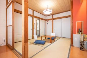 a living room with orange walls and a table and chairs at KYARA Hotel 白鳥 in Tokyo