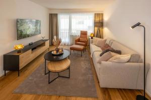 a living room with a couch and a table at Seventh Sky - the luxury one by Inspring Places Zermatt in Zermatt