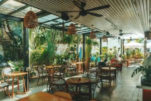 a restaurant with tables and chairs and plants at Sanya IPK BACKPACKERS HOSTEL in Sanya