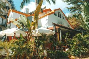 a house with trees and plants in front of it at Sanya IPK BACKPACKERS HOSTEL in Sanya