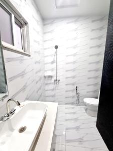 拉合爾的住宿－Hotel Grand Pakeeza，白色的浴室设有水槽和卫生间。