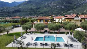 a villa with a swimming pool and mountains in the background at Arcovacanze in Arco