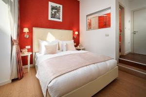 a bedroom with a large bed with red walls at Marmont City Rooms in Split