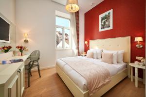 une chambre avec un lit avec un mur rouge dans l'établissement Marmont City Rooms, à Split