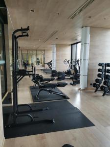 a gym with a row of treadmills and machines at 小憩 屋顶无边泳池 terminal21 Phrom phong Asok 21航站楼 阿索 in Bangkok