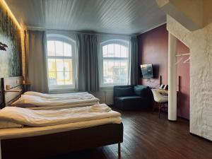 ラウマにあるHotel Sleep at Raumaのベッド2台とソファが備わるホテルルームです。