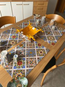 uma mesa com um plano de brinquedo em cima de uma mesa de mosaico em Casavacanze Onda Blu em Mascali