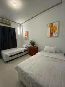 a bedroom with two beds in a room at Lorent Hostel Near Padang Beach in Padang
