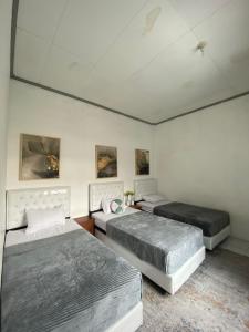 1 dormitorio con 2 camas y techo en LORENT HOSTEL Nipah, en Padang