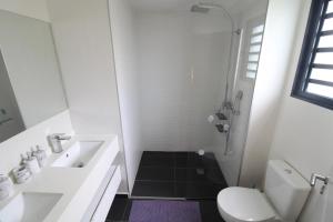 ein weißes Bad mit einem Waschbecken und einem WC in der Unterkunft Heiata Sky apartment 3 bedr in Papeete pool & gym garden Wi-Fi Netflix in Papeete