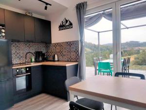 a kitchen with a table and a dining room with a view at WIDOKOVO - Relax, cisza,widoki, sauna & jacuzzi wliczone w cenę in Laski