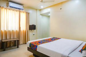 1 dormitorio con 1 cama y TV en FabExpress Sun N Shine, en Pune