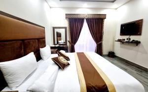 a bedroom with a large bed and a window at Hotel Grand Pakeeza in Lahore