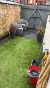 a yard with a lawn mower on the grass at 3 bedroom house with modern interior, close to the Etihad stadium in Manchester