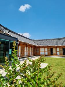 un bâtiment avec une cour d'herbe devant lui dans l'établissement Wonhwaroo, à Gyeongju