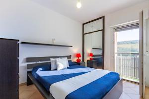 a bedroom with a large bed and a large window at Appartamento L'Approdo Trilo Rosso - MyHo Casa in Marina di Montenero