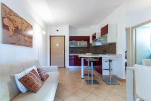a living room with a couch and a kitchen at Appartamento L'Approdo Trilo Rosso - MyHo Casa in Marina di Montenero