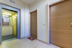 a hallway with a wooden door and a mirror at Appartamento L'Approdo Trilo Rosso - MyHo Casa in Marina di Montenero