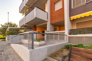 a building with stairs and a bench in front of it at Appartamento L'Approdo Trilo Rosso - MyHo Casa in Marina di Montenero