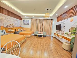 a hotel room with two beds and a couch at FLC Sea Tower Quy Nhơn, ban công view biển, bồn tắm, hồ bơi có phí , gần quản trường in Quy Nhon