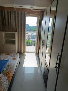 - une chambre avec un lit et une grande fenêtre dans l'établissement Shell Residences, à Manille