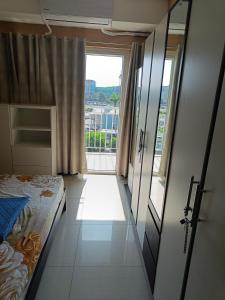 a bedroom with a bed and a large window at Shell Residences in Manila