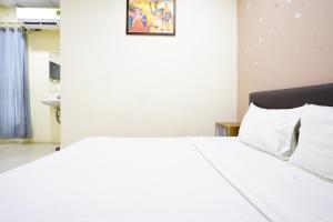 a bedroom with a large white bed with white pillows at Hotel Silver in Surat