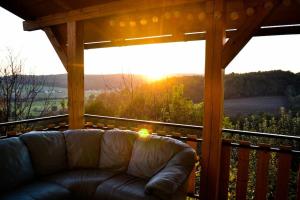 a couch on a porch with a view of the sunset at Papa Franks House in Ptuj