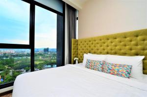 1 dormitorio con cama blanca y ventana grande en Expressionz Professional Suites Kuala Lumpur en Kuala Lumpur
