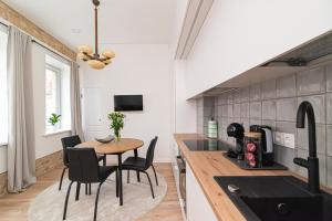 a kitchen and dining room with a table and chairs at New & Stylish Old Town Apartment by URBAN RENT in Vilnius